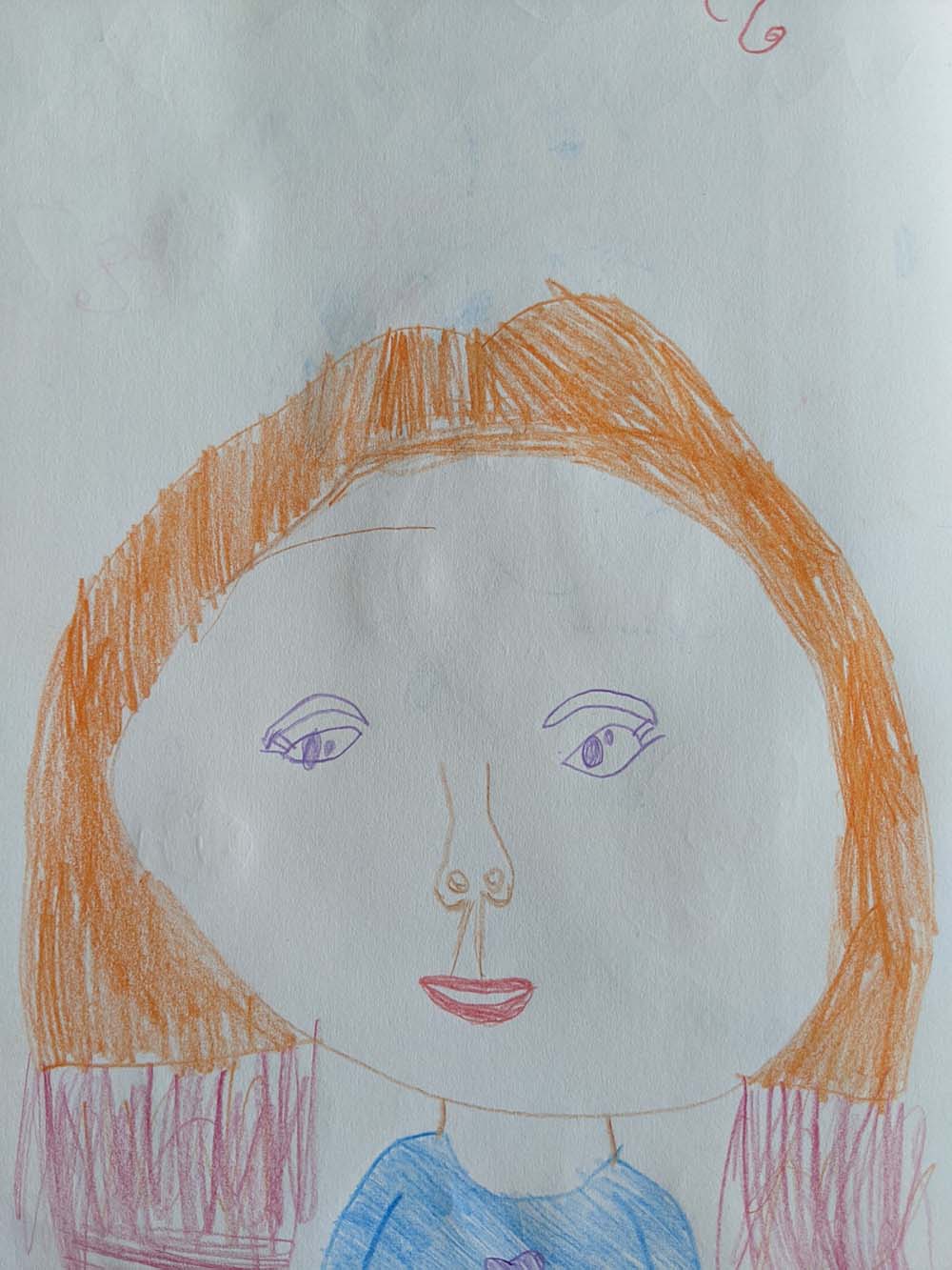 A portrait of a girl with orange hair that is dyed at the ends. She is wearing a blue shirt and smiling. Her nose looks like a regular person's nose.